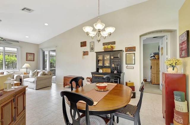 tiled dining area with ceiling fan with notable chandelier and vaulted ceiling