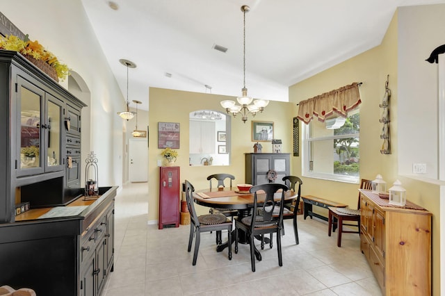 tiled dining room featuring a chandelier and vaulted ceiling