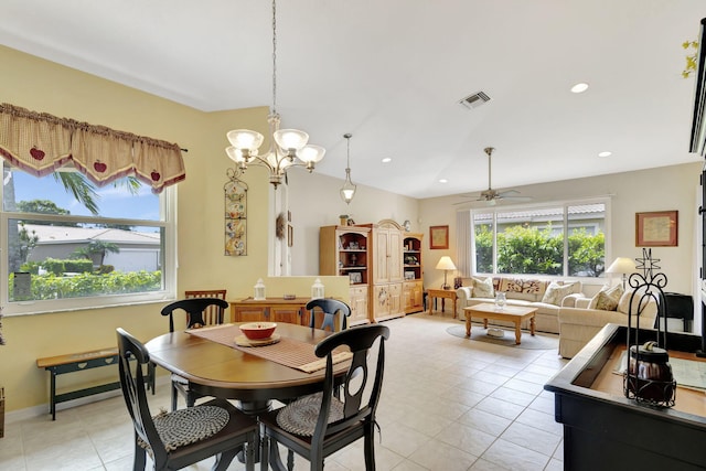 tiled dining area featuring ceiling fan with notable chandelier