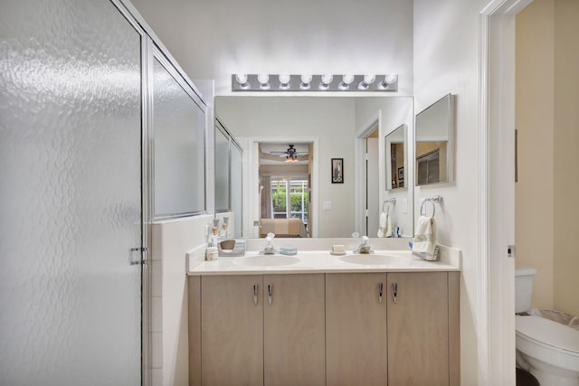 bathroom with vanity, toilet, walk in shower, and ceiling fan