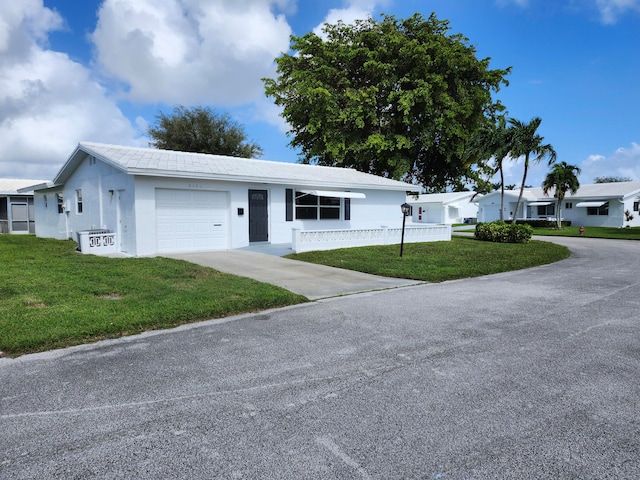 single story home featuring a front lawn and a garage