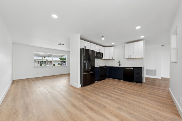 kitchen featuring light hardwood / wood-style floors, white cabinetry, sink, and black appliances