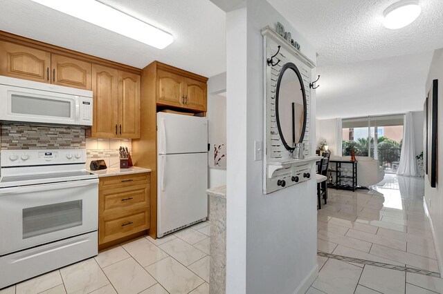 kitchen with decorative backsplash, a textured ceiling, and white appliances