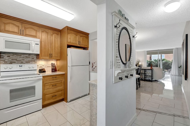 720 E Ocean Ave Unit 303, Boynton Beach, FL 33435 - kitchen with marble finish floor, light countertops, white appliances, decorative backsplash, and a textured ceiling
