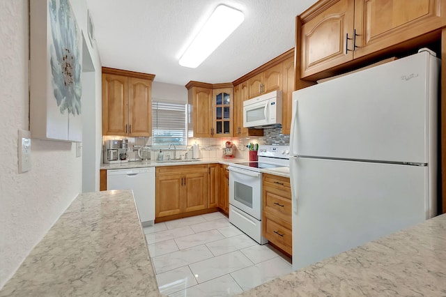 kitchen featuring sink, decorative backsplash, a textured ceiling, and white appliances