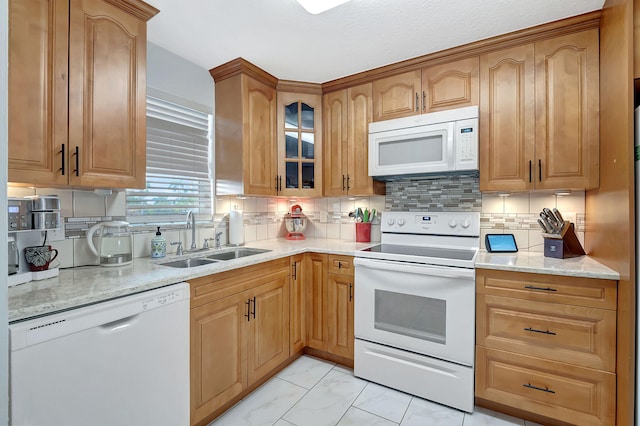 kitchen featuring backsplash, sink, light stone counters, and white appliances