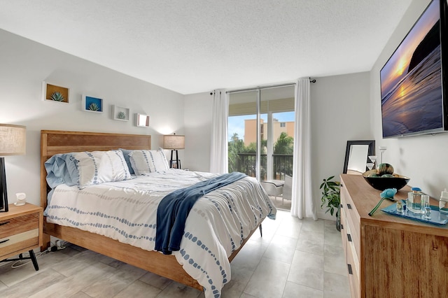 bedroom with access to outside and a textured ceiling