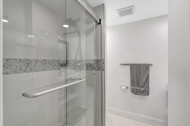 bathroom with walk in shower and tile patterned flooring