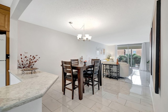 tiled dining area featuring a textured ceiling and a chandelier