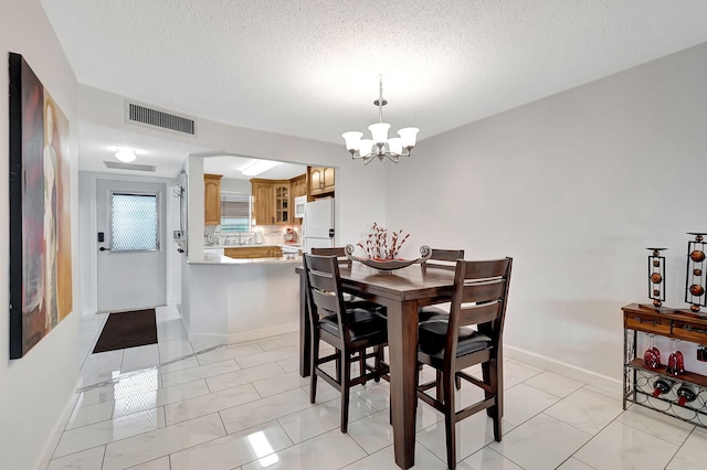 720 E Ocean Ave Unit 303, Boynton Beach, FL 33435 - dining room featuring a chandelier, a textured ceiling, visible vents, and baseboards
