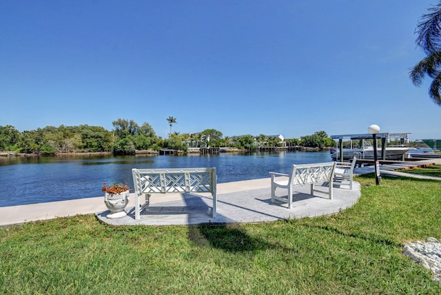 view of dock with a water view and a lawn