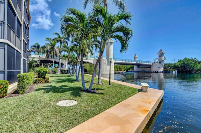 view of property's community with a water view and a lawn