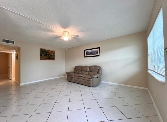 living area with light tile patterned flooring, a textured ceiling, and ceiling fan