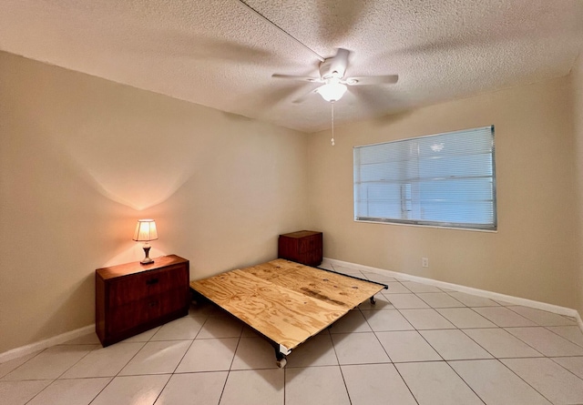 bedroom featuring a textured ceiling, light tile patterned floors, and ceiling fan