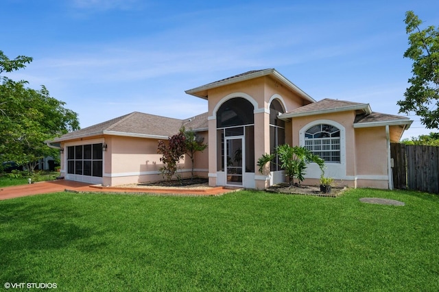 view of front of house with a front lawn and a sunroom