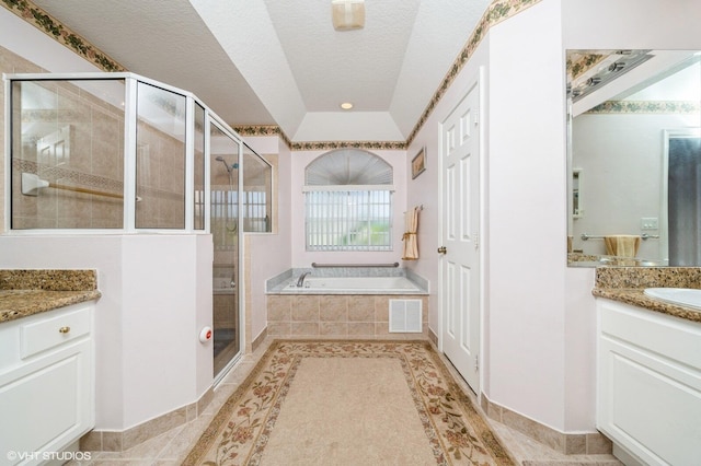 bathroom with vanity, a textured ceiling, and plus walk in shower