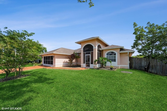 view of front of home featuring a front lawn and a sunroom