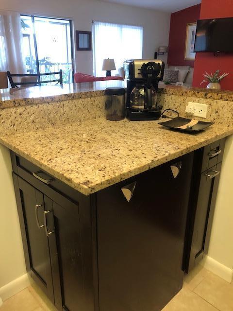 kitchen featuring light tile patterned flooring and light stone counters