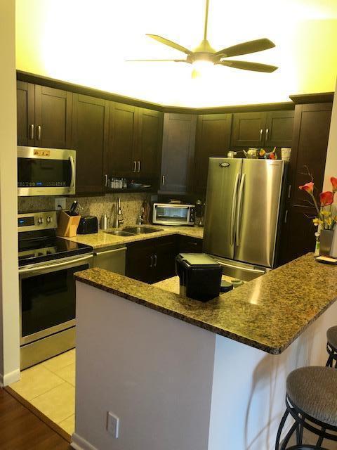 kitchen featuring a breakfast bar, appliances with stainless steel finishes, sink, and dark stone counters