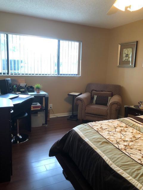 bedroom with dark hardwood / wood-style flooring, a textured ceiling, multiple windows, and ceiling fan