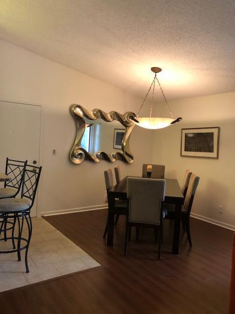 dining space with hardwood / wood-style floors and a textured ceiling