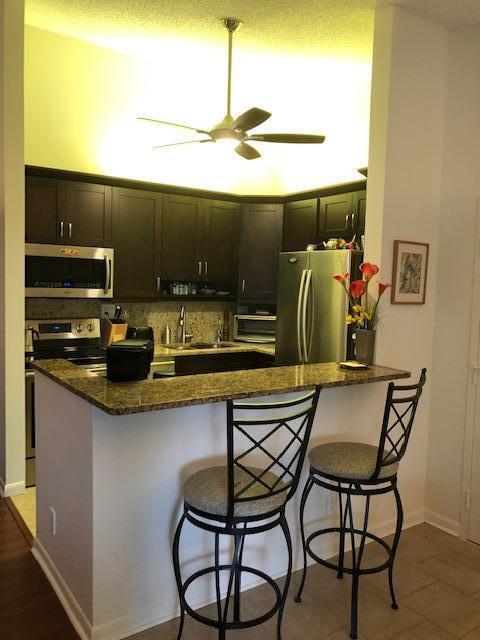 kitchen featuring appliances with stainless steel finishes, tasteful backsplash, dark stone counters, and a breakfast bar area