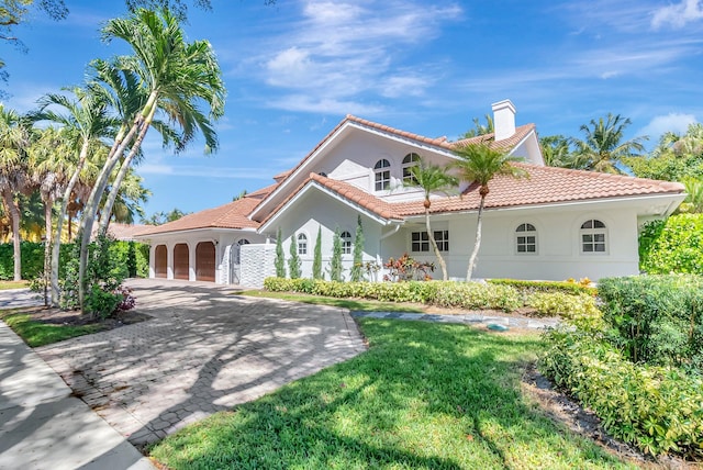 930 N Parkside Cir N, Boca Raton, FL 33486 - mediterranean / spanish home with a front yard, stucco siding, a chimney, a tiled roof, and decorative driveway