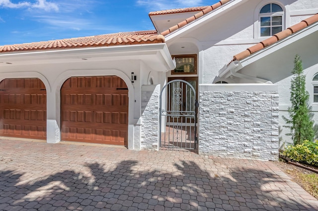 930 N Parkside Cir N, Boca Raton, FL 33486 - view of front of home featuring a tiled roof, stucco siding, decorative driveway, a garage, and a gate