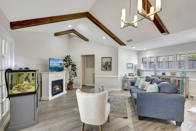 living room featuring beamed ceiling, wood-type flooring, a chandelier, a textured ceiling, and high vaulted ceiling