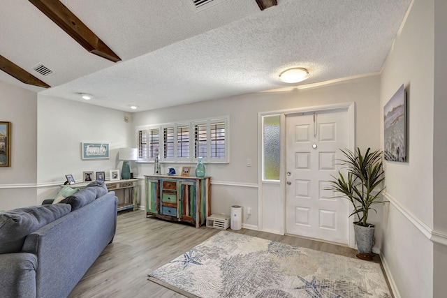 foyer with a textured ceiling and light hardwood / wood-style flooring