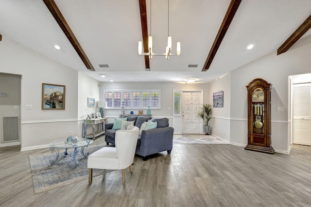 living room featuring vaulted ceiling with beams, an inviting chandelier, and light hardwood / wood-style floors