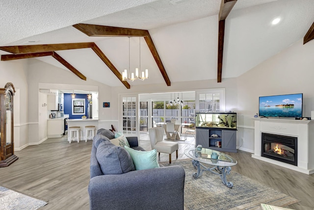 living room with beamed ceiling, hardwood / wood-style floors, a textured ceiling, and a chandelier