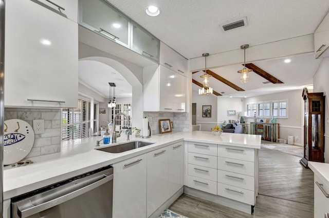 kitchen featuring a wealth of natural light, sink, kitchen peninsula, and dishwasher