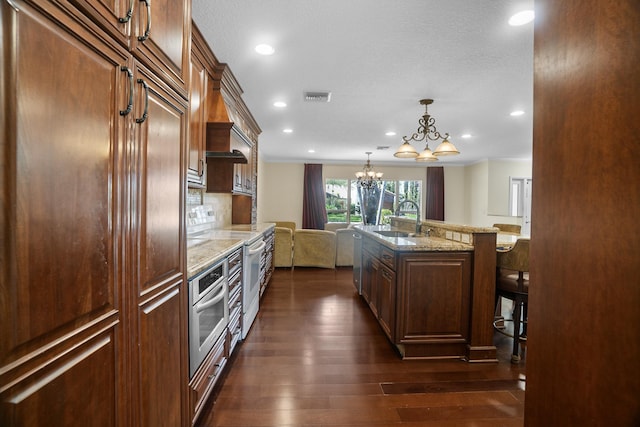 100 SW 15th Ct, Boca Raton, FL 33486 - kitchen with visible vents, a chandelier, oven, a sink, and a breakfast bar area