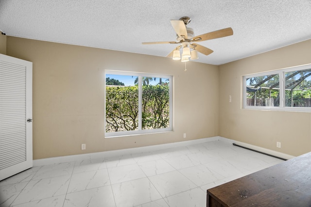 100 SW 15th Ct, Boca Raton, FL 33486 - empty room featuring a ceiling fan, marble finish floor, baseboards, and a textured ceiling