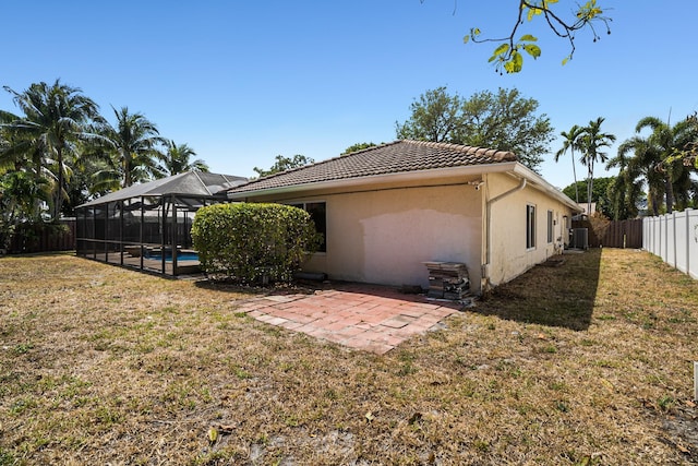 100 SW 15th Ct, Boca Raton, FL 33486 - back of property with glass enclosure, a patio area, stucco siding, a fenced backyard, and a tiled roof