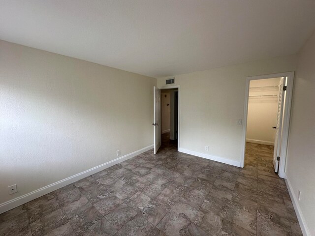 unfurnished bedroom with a spacious closet and a closet