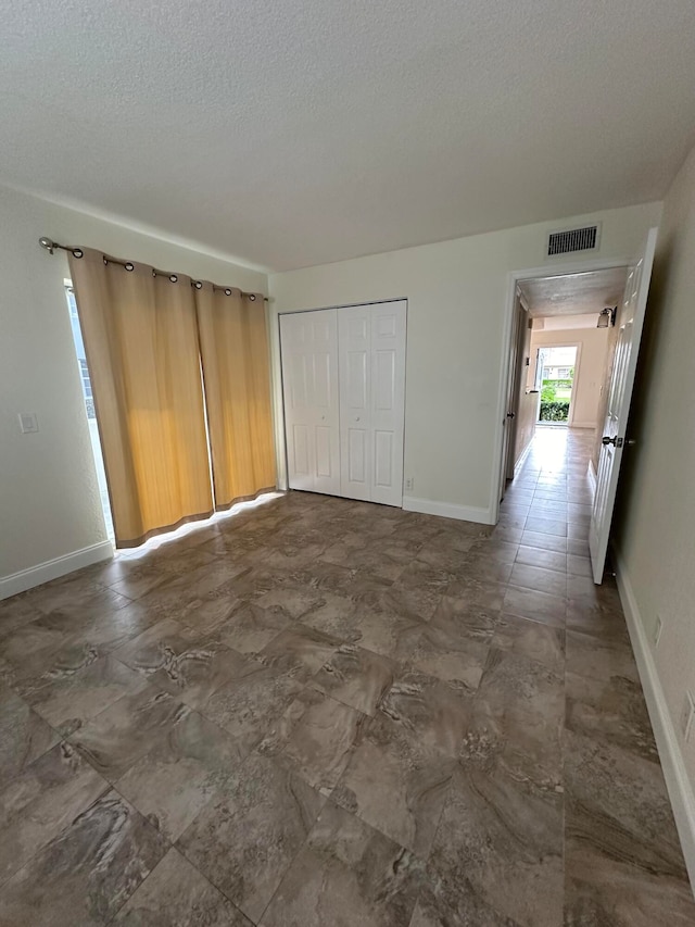 unfurnished room with a textured ceiling