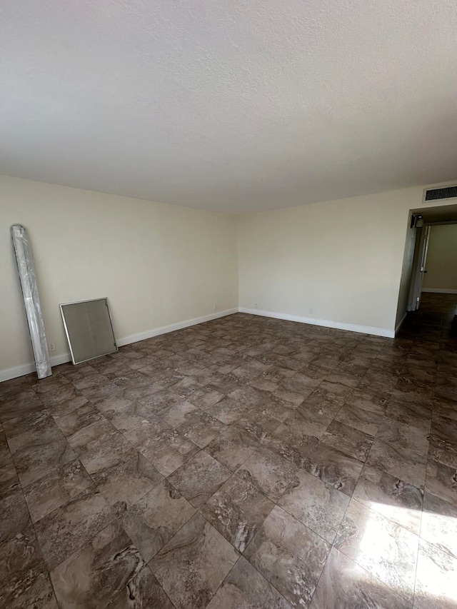 unfurnished room featuring a textured ceiling