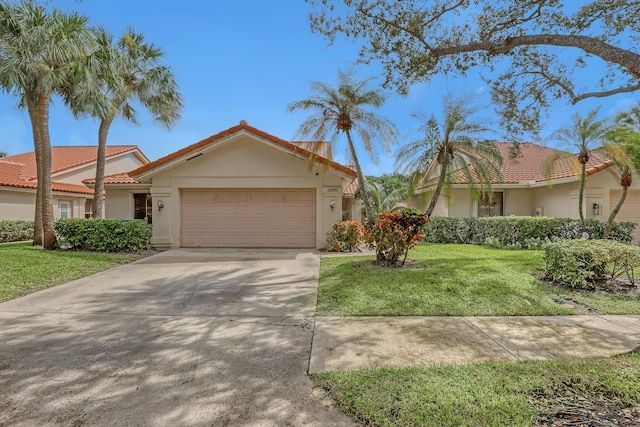 mediterranean / spanish-style house with a front yard and a garage