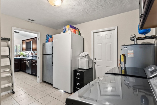 kitchen featuring light tile patterned floors, separate washer and dryer, appliances with stainless steel finishes, water heater, and dark brown cabinets