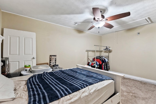 carpeted bedroom with ceiling fan and a textured ceiling