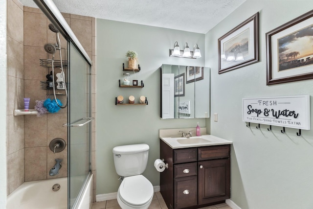 full bathroom featuring vanity, shower / bath combination with glass door, tile patterned flooring, toilet, and a textured ceiling