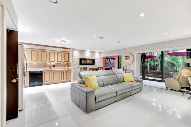 tiled living room with sink, crown molding, and a fireplace