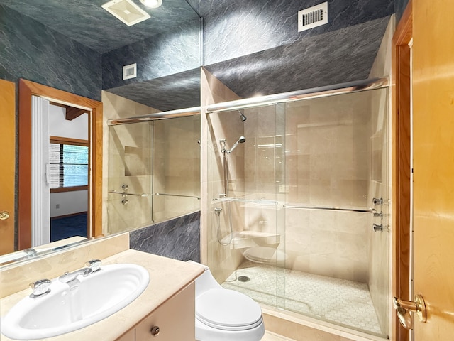 bathroom with toilet, vanity, tile walls, and walk in shower