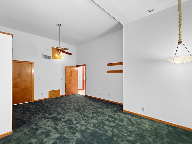 empty room with ceiling fan, high vaulted ceiling, and dark colored carpet