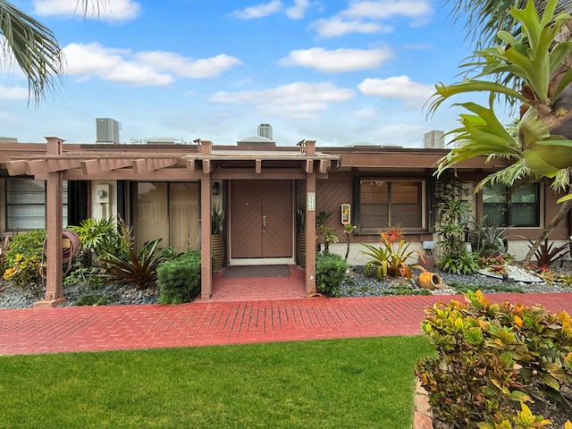 view of front of home featuring a pergola, a front lawn, and cooling unit