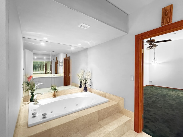 bathroom with vanity and tiled tub