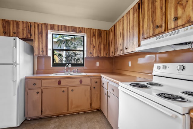 kitchen with light tile patterned floors, white appliances, and sink