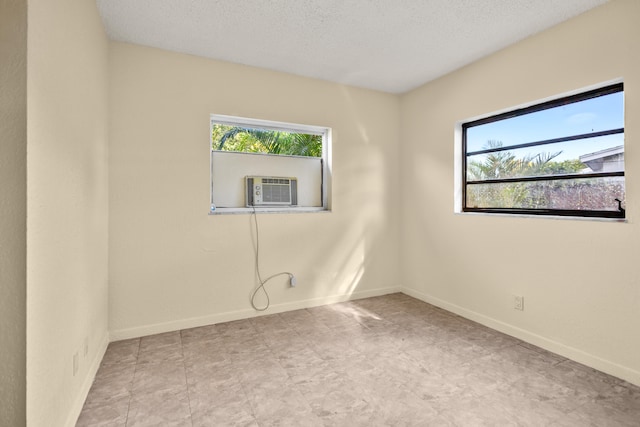 unfurnished room featuring cooling unit and a textured ceiling